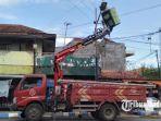 petugas-dinas-perhubungan-samoang-saat-memperbaiki-lampu-penerangan-jalan-umum.jpg