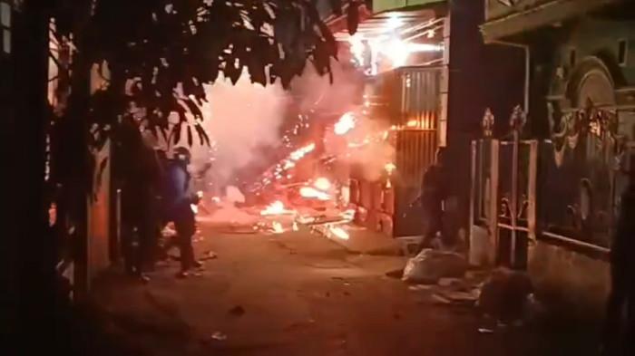 TAWURAN WARGA - Tangkapan layar video saat personel Polrestabes Makassar diserang petasan oleh pelaku tawuran di Jl Tinumbu Lorong 148, Kecamatan Tallo, Makassar, Rabu (19/11/2025) malam