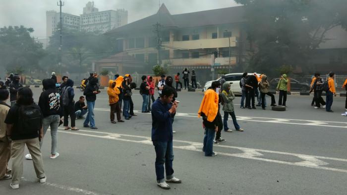 AKSI MAHASISWA UNM - Puluhan mahasiswa menggelar unjuk rasa di depan Kampus Universitas Negeri Makassar, Jalan AP Pettarani, Kecamatan Rappocini, Kota Makassar, Kamis (22/1/2026) siang. Aksi penolakan Plh Rektor dari luar kampus ini diwarnai pembakaran ban dan pemblokiran jalan hingga menyebabkan kemacetan.