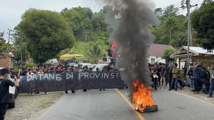 LUWU RAYA - Aliansi Pemekaran Luwu Raya unjuk rasa di Jalan Trans Sulawesi, Kelurahan Sampoddo, Kecamatan Wara Selatan, Kota Palopo, Sulawesi Selatan, Kamis (8/1/2026) sore. Demonstran menutup jalan hingga mengakibatkan kemacetan panjang.