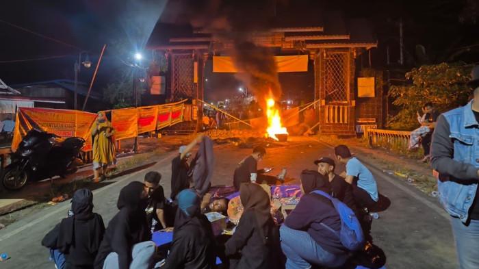 LUWU RAYA - Aksi demonstrasi Mahasiswa-Masyarakat Larompong-Larompong Selatan saat memblokade Jalan Poros Makassar-Palopo di gapura perbatasan Kabupaten Luwu-Wajo di Kecamatan Larompong Selatan, Jumat (23/1/2026) malam.
 