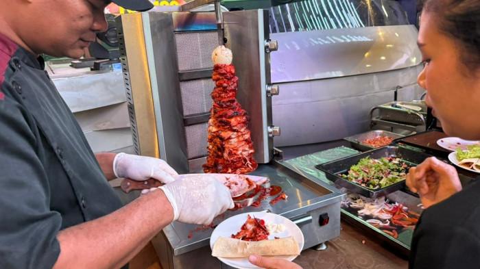 MAKAN SEPUASANYA DI CLARO - Staf Hotel Claro Makassar menyajikan Chicken Shawarma kepada tamu di event Kampoeng Liquid Ramadan 2026 di Claro Makassar, Jalan AP Pettarani, Kota Makassar Minggu (22/2/2026). Shawarma salah satu menu favorit Kampoeng Liquid Ramadan 2026.
