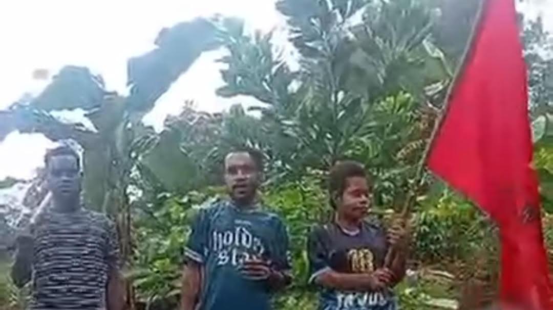 2025-12-16-tiga-orang-asal-Papua-membawa-bendera-Komite-Nasional-Papua-Barat-KNPB.jpg
