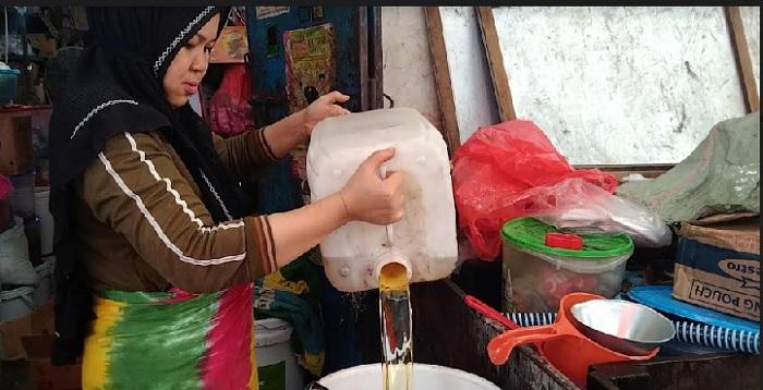 Istri-Pak-Herman-sedang-memindahkan-minyak-curah-di-kiosnya-di-Pasar-Lakessi.jpg