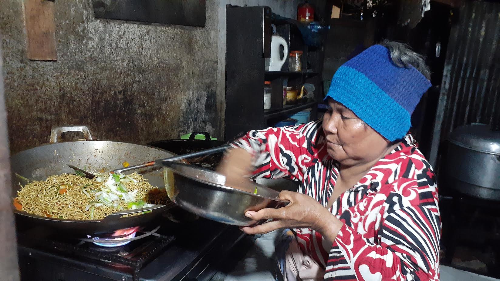 maria-daeng-lummu-sedang-memasak-mie-untuk-pelengkap-menu-nasi-kuningnya.jpg