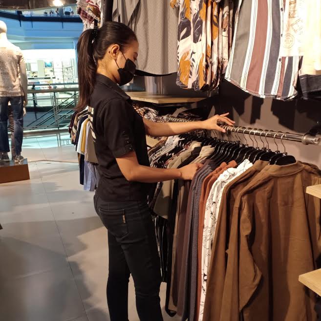 seorang-petugas-tenant-sedang-merapikan-pakaian-di-tenant-mari.jpg