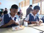 MAKAN-GATIS-Siswa-SMP-1-Makassar-mencicipi-makan.jpg