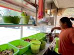 Pemilik-warung-makanan-Gadena-PKH-Naila-19-saat-menyiapkan-orderan-nasi-campur.jpg