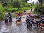 Sejumlah-warga-mencuci-motor-di-titik-jalan-yang-dialiri-air-sungai-di-Desa-Rossoan.jpg