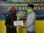 armiadi-kanan-menyerahkan-blt-dd-kepada-salah-satu-penerima-di-desa-laba.jpg