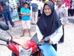 femi-aprilia-bahar-saat-menerima-hadiah-utama-satu-unit-sepeda-motor.jpg