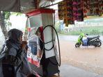 huzaimah-memakai-jas-hujan-di-depan-kolam-regulasi-nipa-nipa.jpg