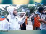 pakai-baju-hazmat-seorang-pria-ajak-masyarakat-keluar-rumah.jpg