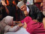 sri-dewi-baju-merah-memeluk-peti-yang-berisikan-jasad-lisa.jpg