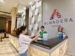 staf-hotel-mengarahkan-tamu-untuk-menggunakan-hand-sanitizer-di-lobi-hotel-almadera-1.jpg<pf>staf-hotel-mengarahkan-tamu-untuk-menggunakan-hand-sanitizer-di-lobi-hotel-almadera.jpg