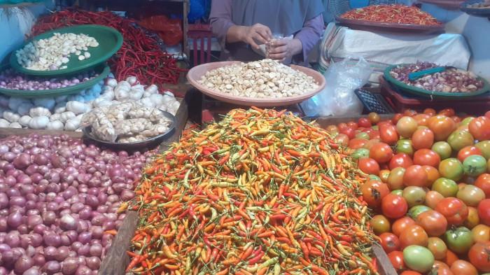 HARGA - Pedagang melayani pembeli bahan pokok di Pasar Bersehati, Kota Manado, Sulawesi Utara, Selasa (21/4/2026). Sejumlah harga komoditas seperti cabai, tomat, bawang hingga daging sapi terpantau mengalami penurunan akibat melimpahnya pasokan, sementara pembeli menyambut positif kondisi tersebut meski pedagang mengaku khawatir harga terus merosot.