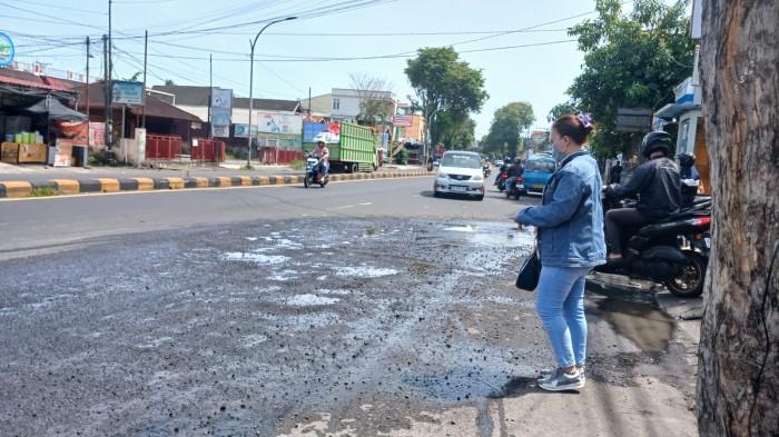 JALAN RUSAK - Aspal berlubang di persimpangan Jalan RW Mongisidi dan Jalan Sea, Malalayang, Manado, Sulawesi Utara, Kamis (15/1/2026). Rusaknya jalan tersebut mengganggu pengguna jalan.