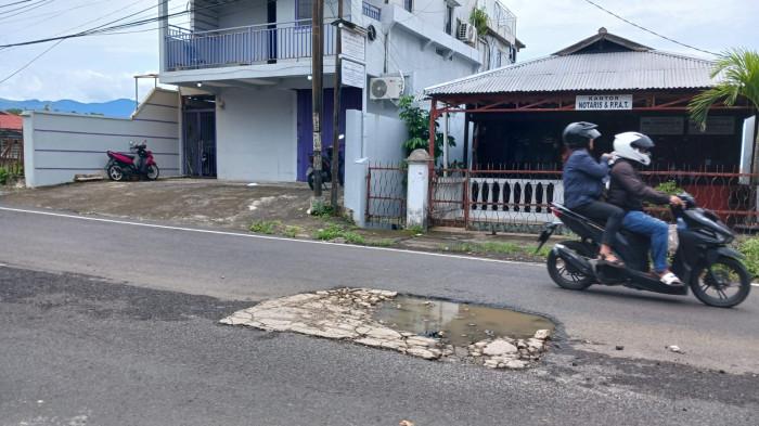 JALAN RUSAK - Kerusakan di Jalan Diponegoro, Wenang, Manado, Sulawesi Utara, Minggu (22/2/2026). Lubang di jalan hanya ditambal semen.