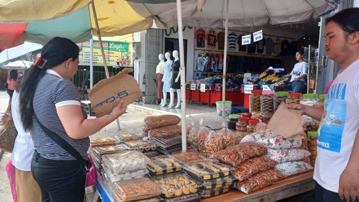 KUE KERING - Penjual kue kering di Pasar 45, Manado, Sulawesi Utara, Selasa (9/12/2025). Seorang penjual bernama Femi mengaku bisa meraup Rp 5 juta dalam sehari.