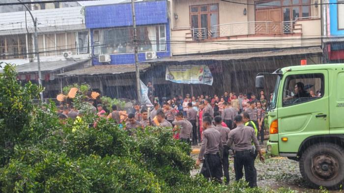 POHON TUMBANG - Pohon beringin besar tumbang di Jalan RW Mongisidi Manado, Sulawesi Utara Jumat (14/11/2025). Personel kepolisian turun ke lokasi untuk mengatasi masalah ini.