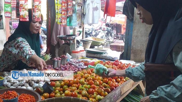 PASAR - Pedagang Agustina Posumah saat menjajakan dagangannya di lapaknya, di Pasar 23 Maret Kotamobagu, Senin (17/11/2025). Update daftar harga beras, rempah hingga bahan dapur.