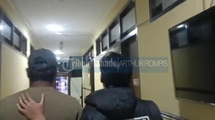 DITANGKAP - Pria asal Bacan, Malut, terduga pelaku (yang mengenakan topi) diamankan aparat ke Polda Sulut. Pria tersebut sebagai terduga pelaku kasus pemerasan Love Scammer terhadap seorang wanita di Bolmong, Sulut. Modusnya