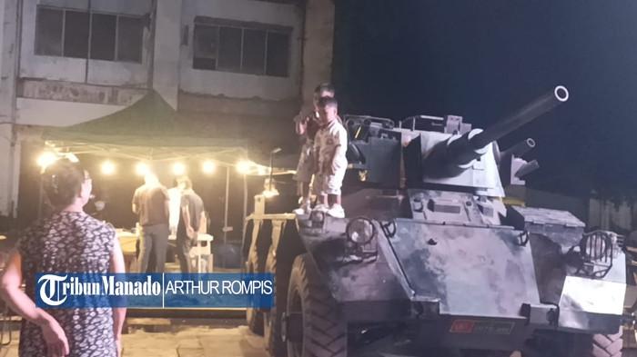 TANK - Satu unit tank terparkir di kawasan kuliner Food Truck, depan eks Blue Banter, Jalan Pierre Tendean, Kecamatan Wenang, Kota Manado, Sulut, Kamis (13/11/2025) malam. Tampak anak-anak menaiki tank tersebut dengan pengawasan orangtua.