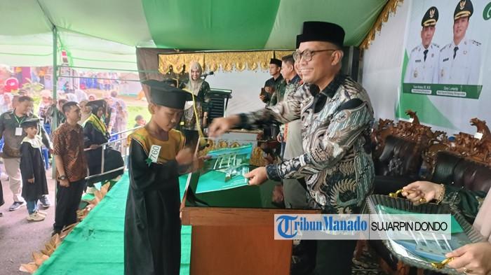 WISUDA - Ribuan santri angkatan XXV Tahun 2025 se-Bolmong Sulawesi Utara, diwisuda di kompleks kantor Bupati Bolmong, Kamis (13/11/2025). Sekda Bolmong Abdullah Mokoginta menjadi pemindah tali toga sebagai tanda kelulusan.