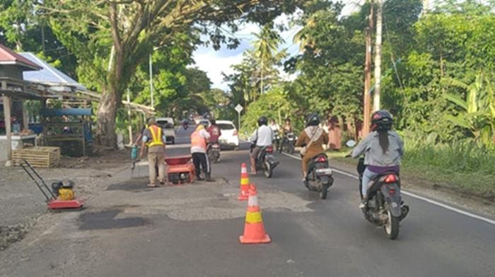 Pekerja-sedang-memperbaiki-jalan-rusak-berlubang-di-Desa-Tontalete-1.jpg