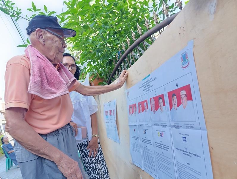 Pemilih-lansia-memperhatikan-contoh-kertas-suara-Pilkada-2024.jpg