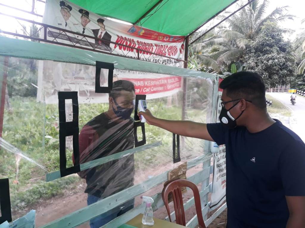 para-pelaku-perjalanan-ketika-diukur-suhu-tubuh-oleh-petugas-perbatasan-desa-adow.jpg