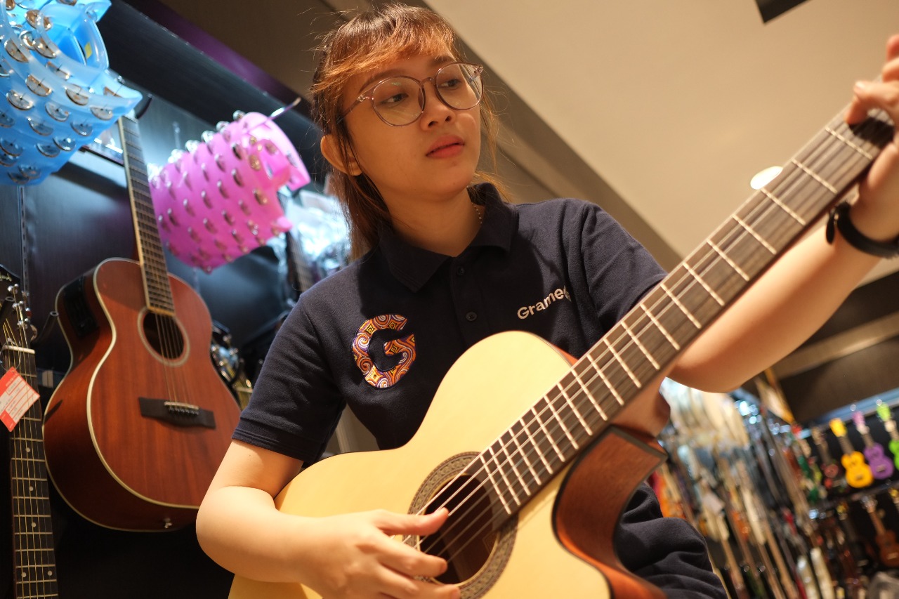 pramuniaga-gramedia-manado-mencoba-salah-satu-gitar-akustik1.jpg