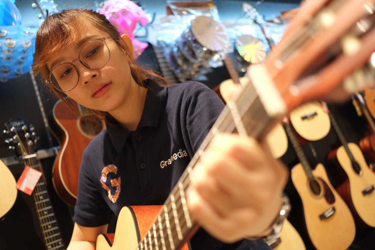 pramuniaga-gramedia-manado-mencoba-salah-satu-gitar-akustik3.jpg