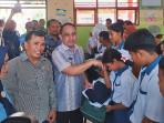 Bupati-Bolmong-Yusra-Alhabsyi-membagikan-seragam-gratis-kepada-siswa-di-SMPN-1-Lolak-Foto.jpg