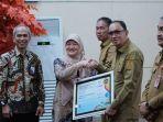 Ft-Prokopim-Cap-Pemerintah-Kabupaten-Pemkab-Minahasa-menerima-penghargaan.jpg