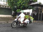 Pengendara-sepeda-motor-di-Manado-menggunakan-baju-hazmat.jpg