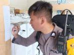 Seorang-petugas-keamanan-di-Bitung-melakukan-cek-dengan-cara-di-centang-tps-sdfasdf.jpg