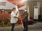 ketua-pengprov-issi-sulut-revino-pepah-kiri-menyerahkan-pataka-issi-kepada-royke-h-kalangi.jpg