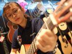 pramuniaga-gramedia-manado-mencoba-salah-satu-gitar-akustik3.jpg