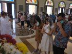 seorang-anak-bersama-orang-tua-memakan-hosti-yang-diberikan-pastor-hgfhgfh.jpg
