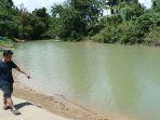 warga-desa-tobayagan-sedang-menujukan-sungai-yang-keruh-dan-lumpurdsfdgdfg.jpg