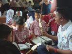 Para-pelajar-SD-membaca-buku-di-dalam-kereta-Rail-Library-KAI.jpg