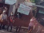 Pria-bentangkan-poster-saat-jokowi-lewat-di-Blitar.jpg