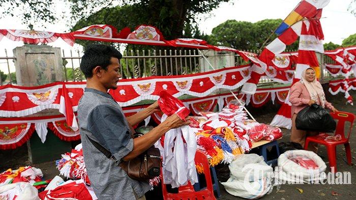 Pedagang musiman bendera melayani pembeli didepan Taman Makam Pahlawan Bukit Barisan Jalan Sisingamangaraja, Kota Medan, Rabu (2/8). Dalam rangka menyambut Hari Ulang Tahun (HUT) Kemerdekaan Republik Indonesia yang ke-78 pada tanggal 17 Agustus 2023, sejumlah pedagang musiman bendera mulai berjualan dipinggir jalan dengan berbagai ukuran dan jenis bendera maupun umbul-umbul bernuansa merah dan putih, dibanderol dengan harga mulai dari Rp 5000 ribu sampai Rp 650 ribu.