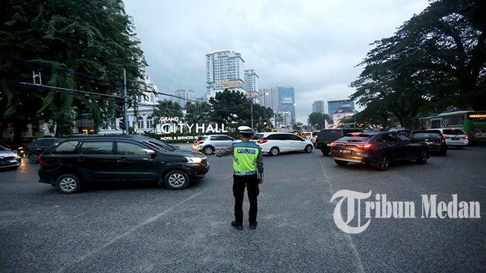 Petugas Kepolisian mengatur arus lalu lintas di Jalan Balai Kota, Kota Medan, Selasa (3/10). Balai Besar Meteorologi, Klimatologi, dan Geofisika (BMKG) Wilayah I Medan mengeluarkan peringatan dini waspada potensi hujan lebat yang dapat disertai petir dan angin kencang di wilayah Sumatera Utara.