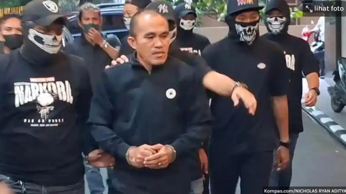 DIGIRING KE BARESKRIM - Mantan Kepala Satuan Reserse Narkoba (Kasatresnarkoba) Polres Kutai Barat (Kubar) AKP Deky Jonathan Sasiang (tengah) terlihat santai berjalan dalam kondisi tangan diborgol saat tiba di Gedung Bareskrim Polri, Jakarta, Senin (18/5/2026).