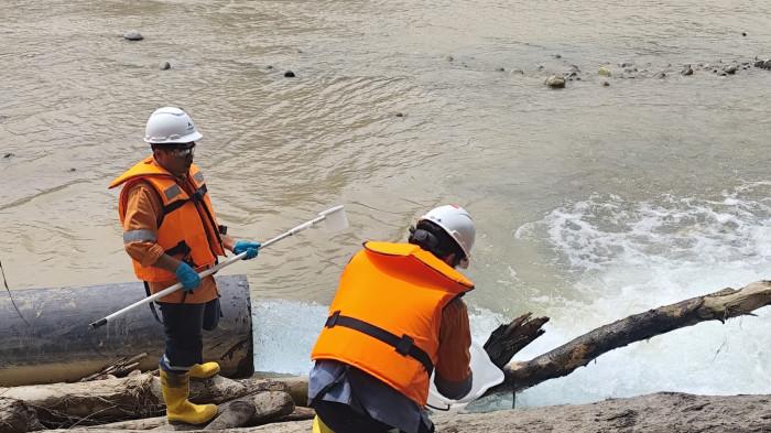 AMBIL SAMPEL - Petugas dari PT Agincourt Resources mengambil air sisa proses limbah yang dialirkan ke Sungai Batangtoru, Minggu (15/2/2026).