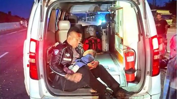 Personel Satuan PJR Ditlantas Polda Riau Aipda Fernandoz Sihombing saat menggendong bayi korban meninggal akibat lakalantas di Tol Pekanbaru-Dumai, Kamis (21/5/2026). (Istimewa/Tribun Pekanbaru)