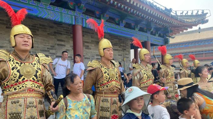 Beberapa pria mengenakan pakaian prajurit Tiongkok kuno berdiri tegak di atas tembok Kota Xi'an, Provinsi Shaanzi. Mereka tetap dalam posisi tegak selayaknya prajurit kendati ada banyak warga yang mengerumuni.