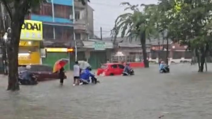 BANJIR MEDAN- Sejumlah warga dan pengendara motor terjebak banjir di salah satu ruas jalan utama di Kota Medan, Kamis (27/11/2025). Hujan deras sejak dini hari membuat air meluap hingga menenggelamkan kendaraan.